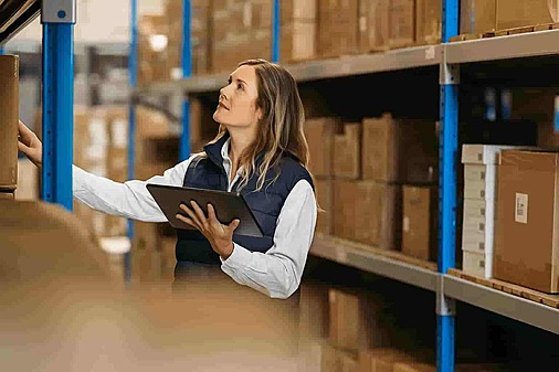 Warehouse employee checking shelves for stock management at NSJ Wholesale